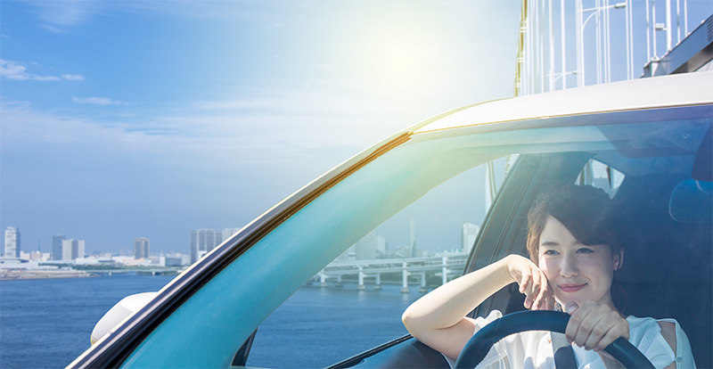 日を浴びながら運転する女性
